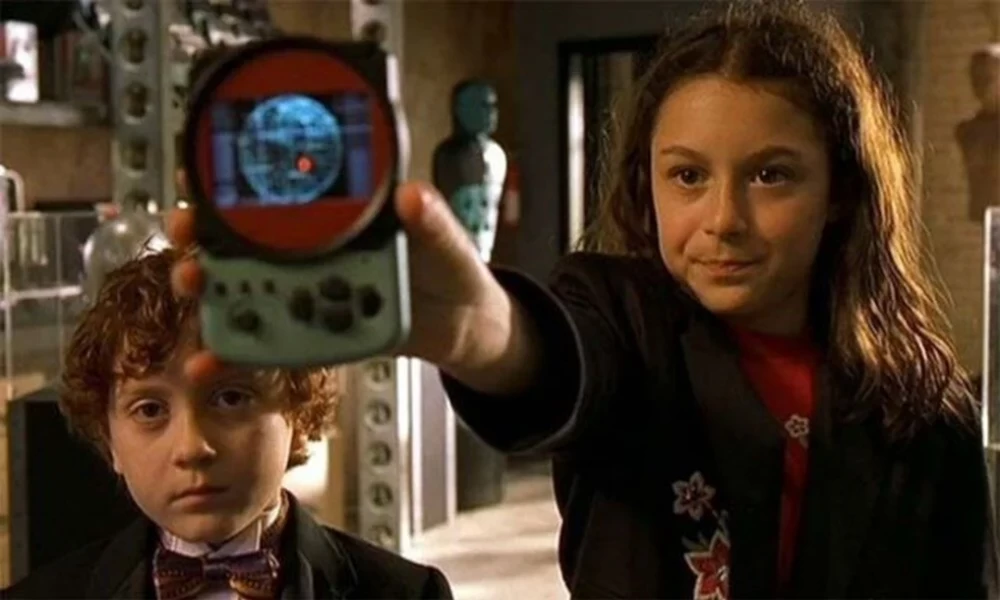 Children play on tablets while sitting on the couch.