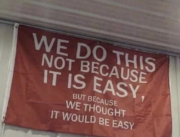 Text on the flag: we do this not because it is easy, we thought it would be easy.