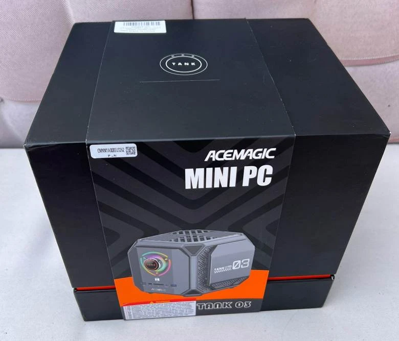 Acemagic Tank 03 Mini-PC on the desk, glowing case in the dim light  
