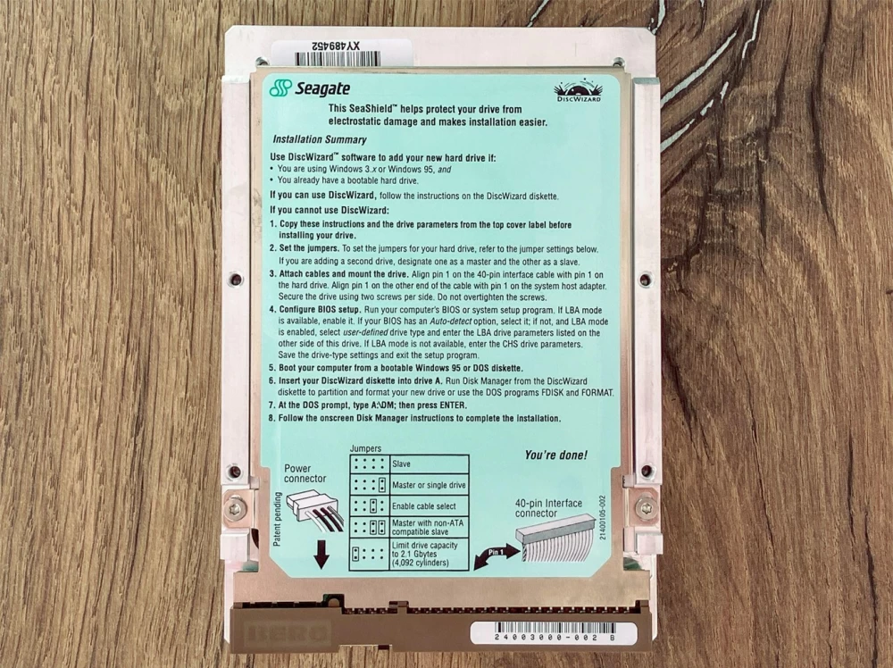 Retro computer in front of a collection of vintage gaming consoles.