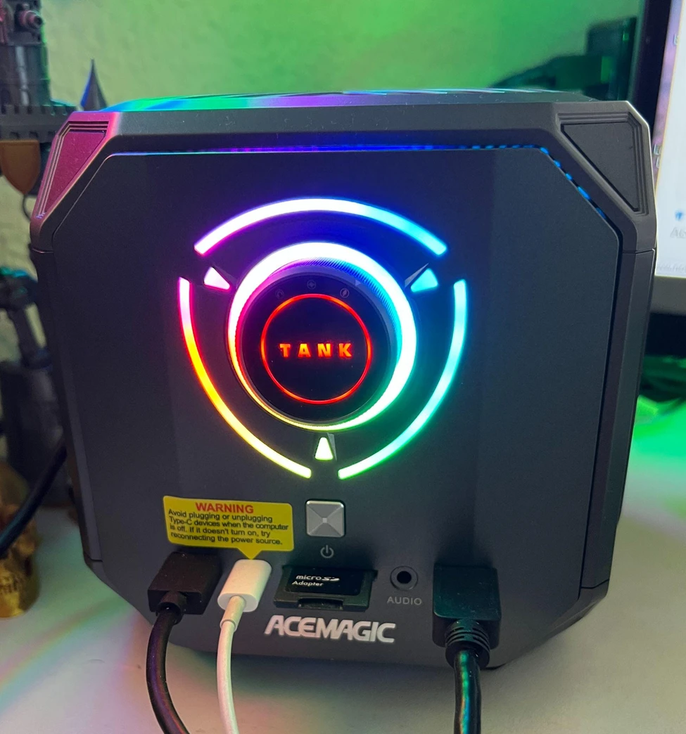   
Overview angle of the Acemagic Tank 03 with connected cables and monitor  
