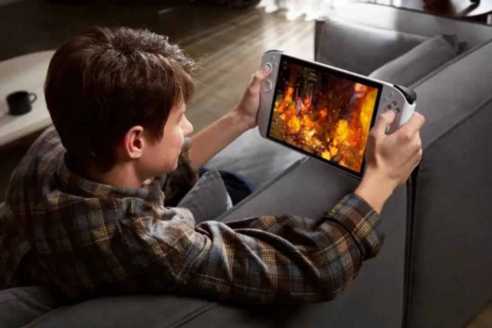 A child unpacks a portable gaming console under the tree