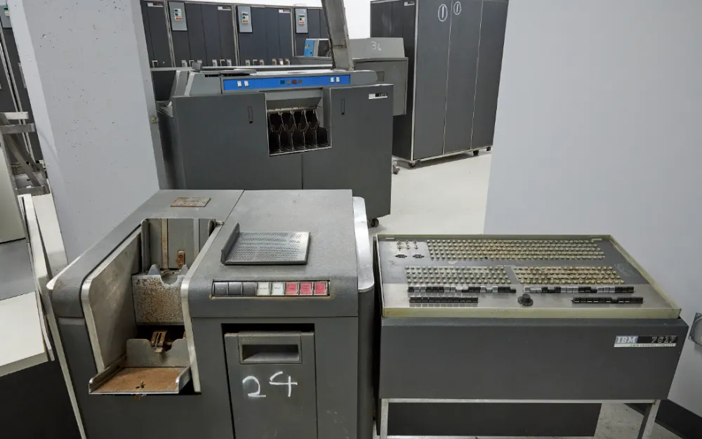 Collectible IBM 7090 mainframe against the background of historical documents